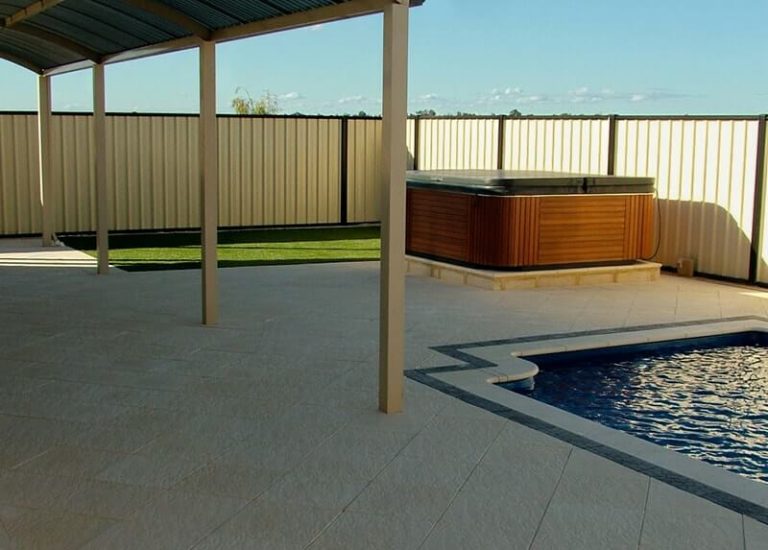 Pool area and spa on raised platform in Castlestone Beach pattern paving and capping
