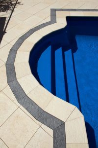 Roman style pool with Castlestone bullnose capping and Pebble border