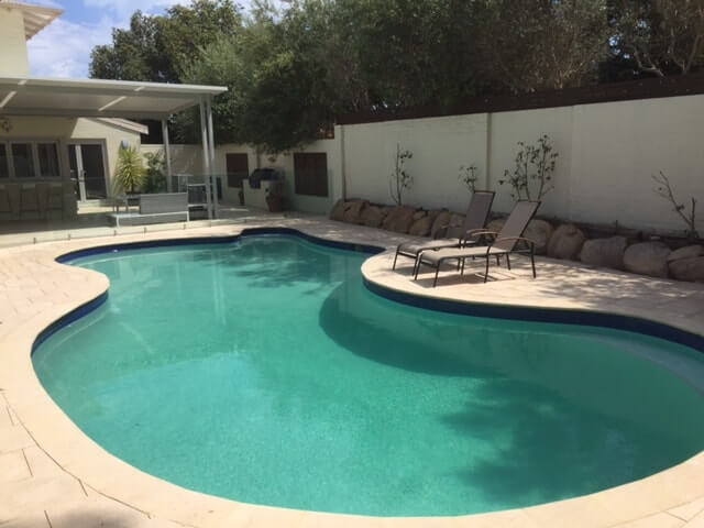 Traditional style curved pool with Beach Champagne pavers & bullnose